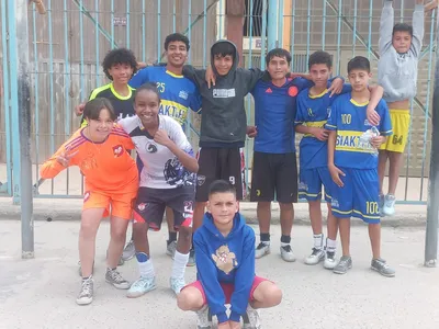 Niños jugando fútbol en la cancha